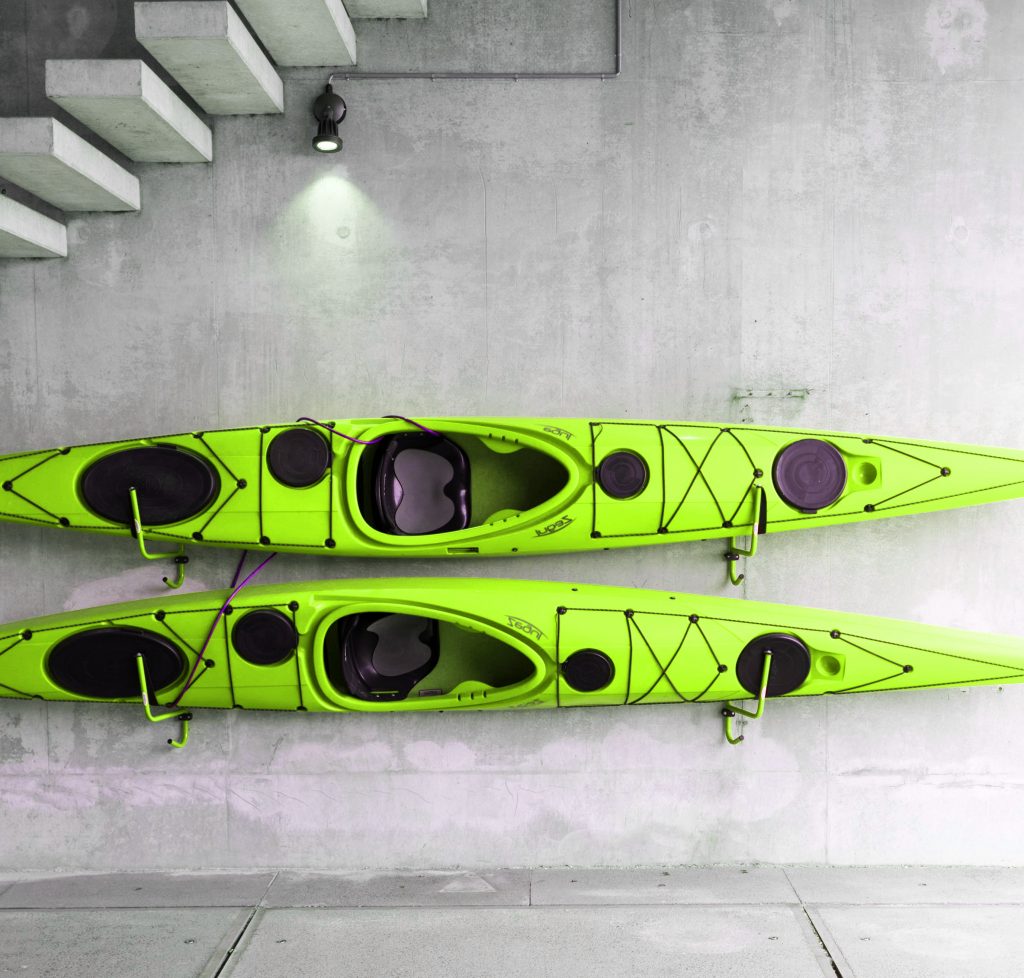 Green kayaks hanging on wall.
