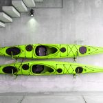 Green kayaks hanging on wall.